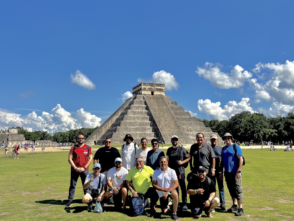 Grupo de viajeros adultos frente a la pirámide de Chichén Itzá
